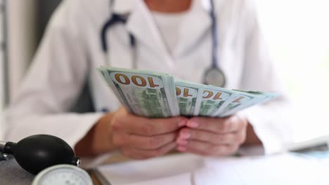 doctor counting hundred dollar bills