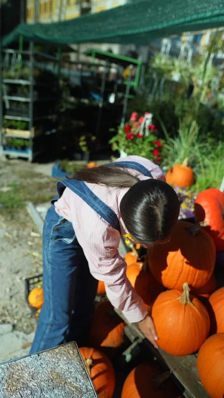 가을 시장 에서 호박 을 선택 하는 젊은 여자