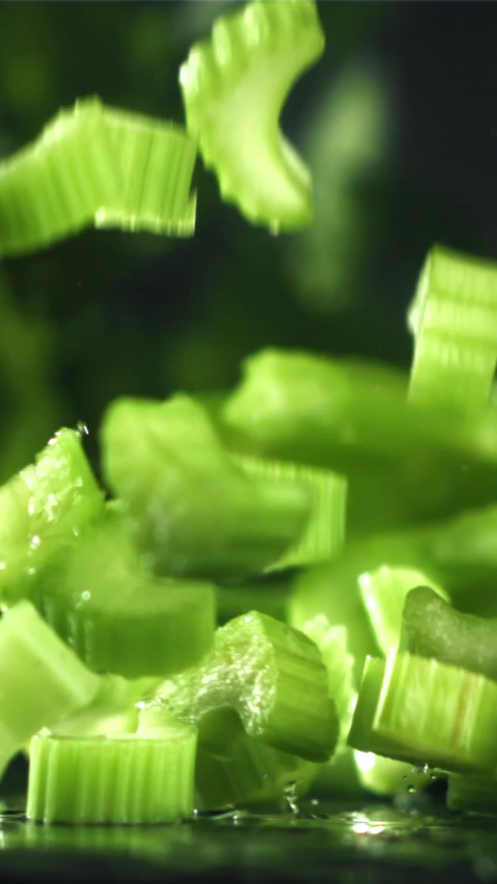 Fresh Green Celery Pieces Falling in Slow Motion