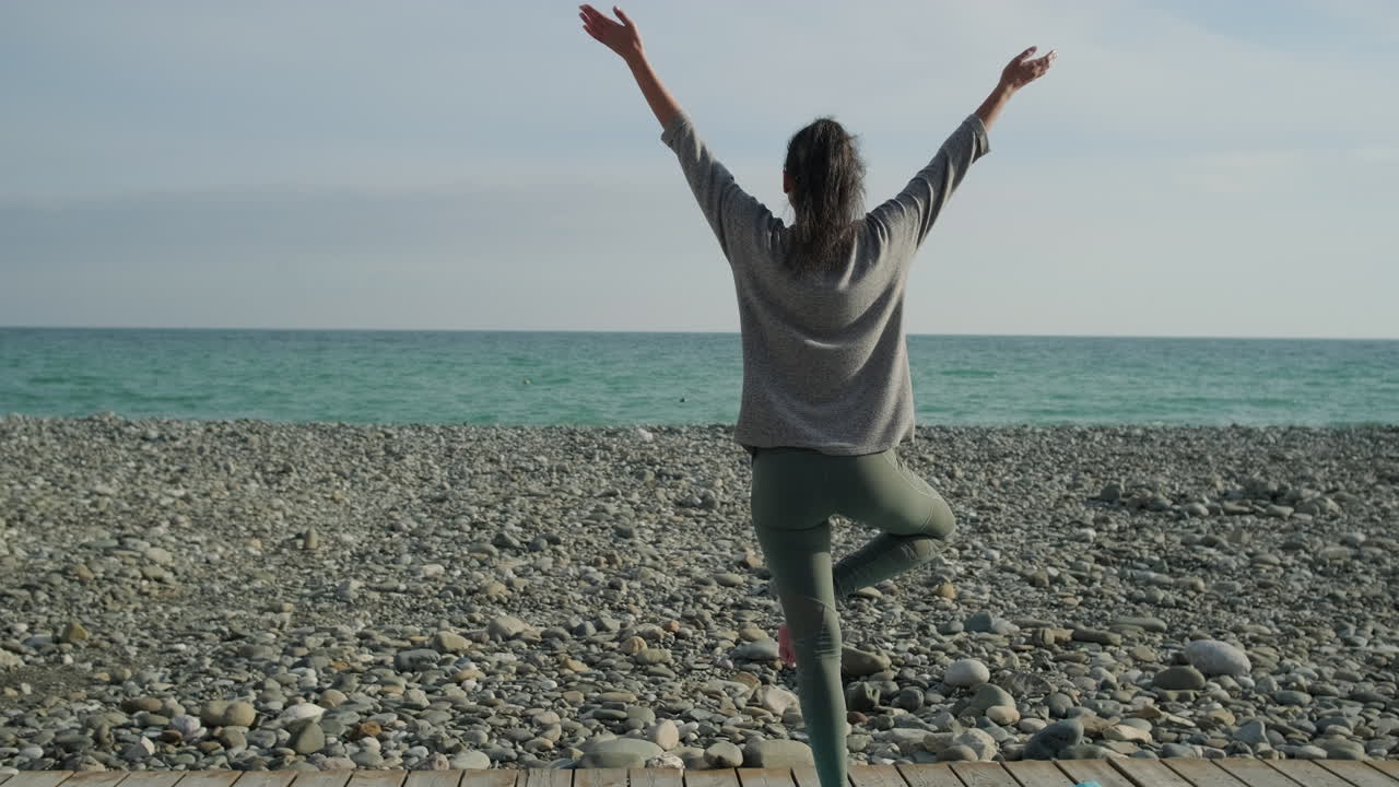 해변에서 요가를 연습하는 여자