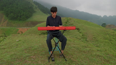 keyboard player sitting down playing instrument. picturesque landscape