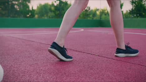 basketball court girl dribbles ball in slow motion and shoots low angle shot