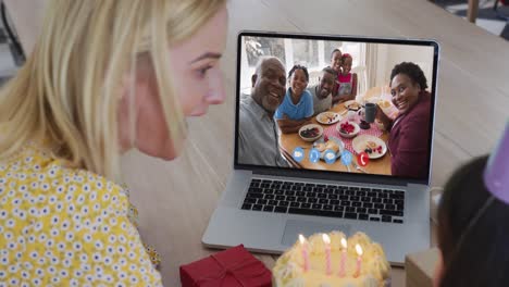 caucasian mother and daughter celebrating birthday having a video call on laptop at home