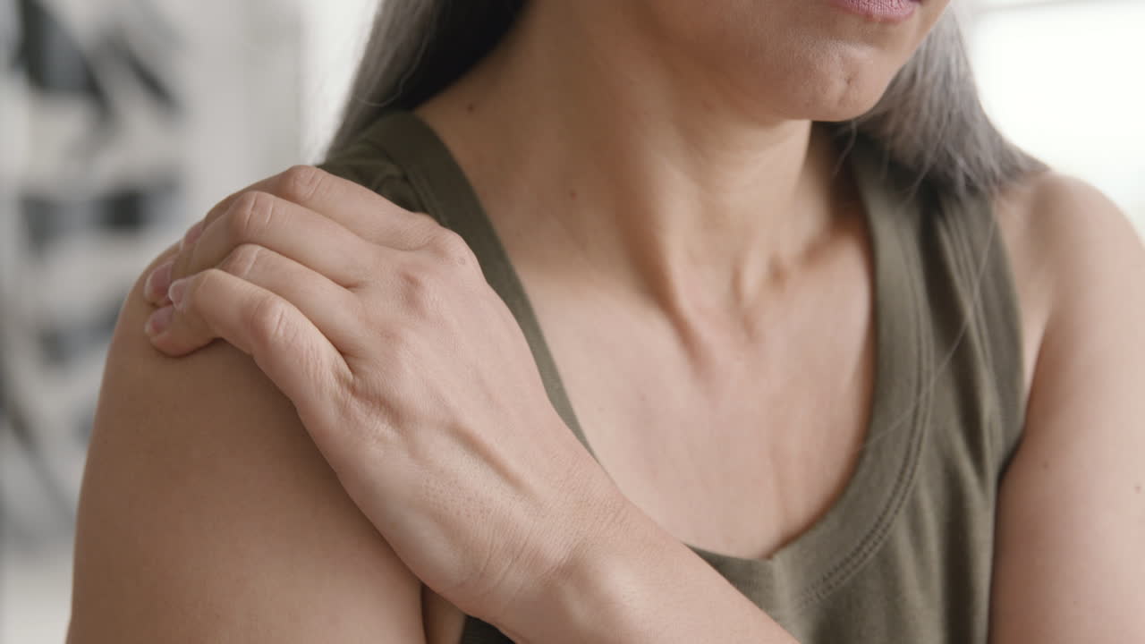 그녀의 고통스러운 어깨를 만지고 중년 여자의 닫습니다