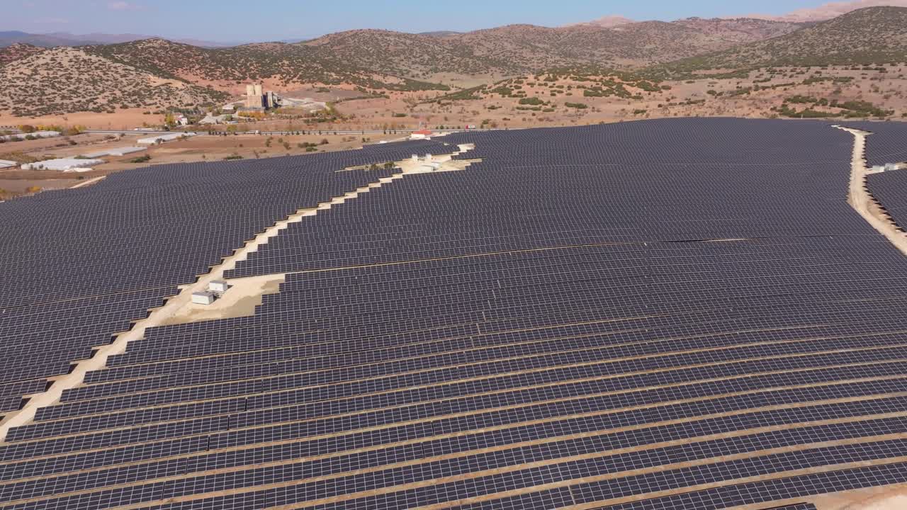 Luftfoto af en solcellepark med ren energi over Cavdirs naturskønne landskab.