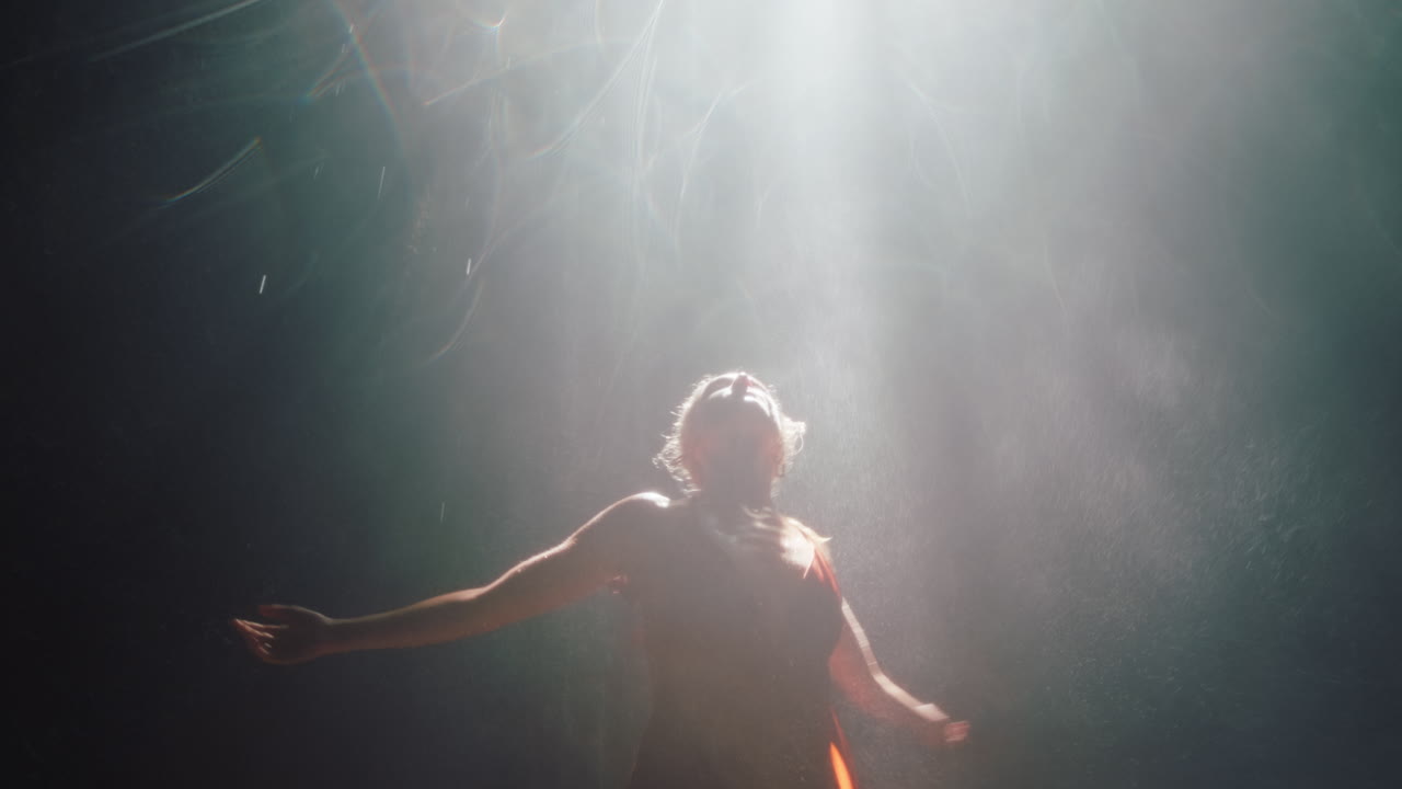 hermosa mujer bailando en la cueva de la cascada con un hermoso vestido disfrutando de la danza sintiendo libertad espiritual 4k