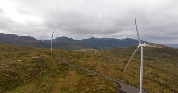 Droneudsigt over vindmøller, der roterer i en vindmøllepark i Sortland kommune, Nordland landskab.