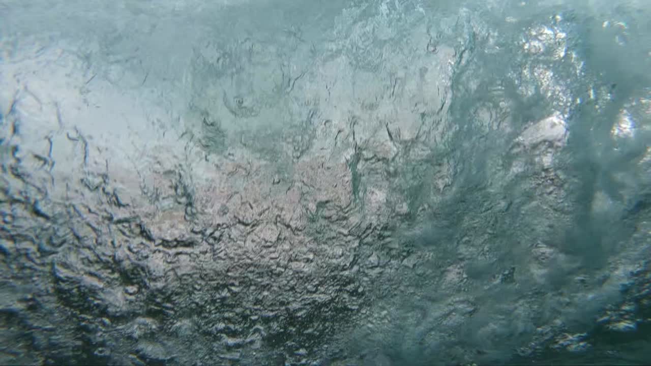 하와이의 해변에 충돌하는 맑은 쇼어브레이크 파도 뒤에서 극단적인 슬로우 모션 샷