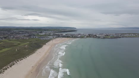 Impresionante-Paisaje-De-La-Ciudad-Costera-Y-La-Playa-De-Whiterocks-De-Portrush-Con-Olas-Oceánicas-En-Portrush,-Irlanda-Del-Norte---Drone-Aéreo