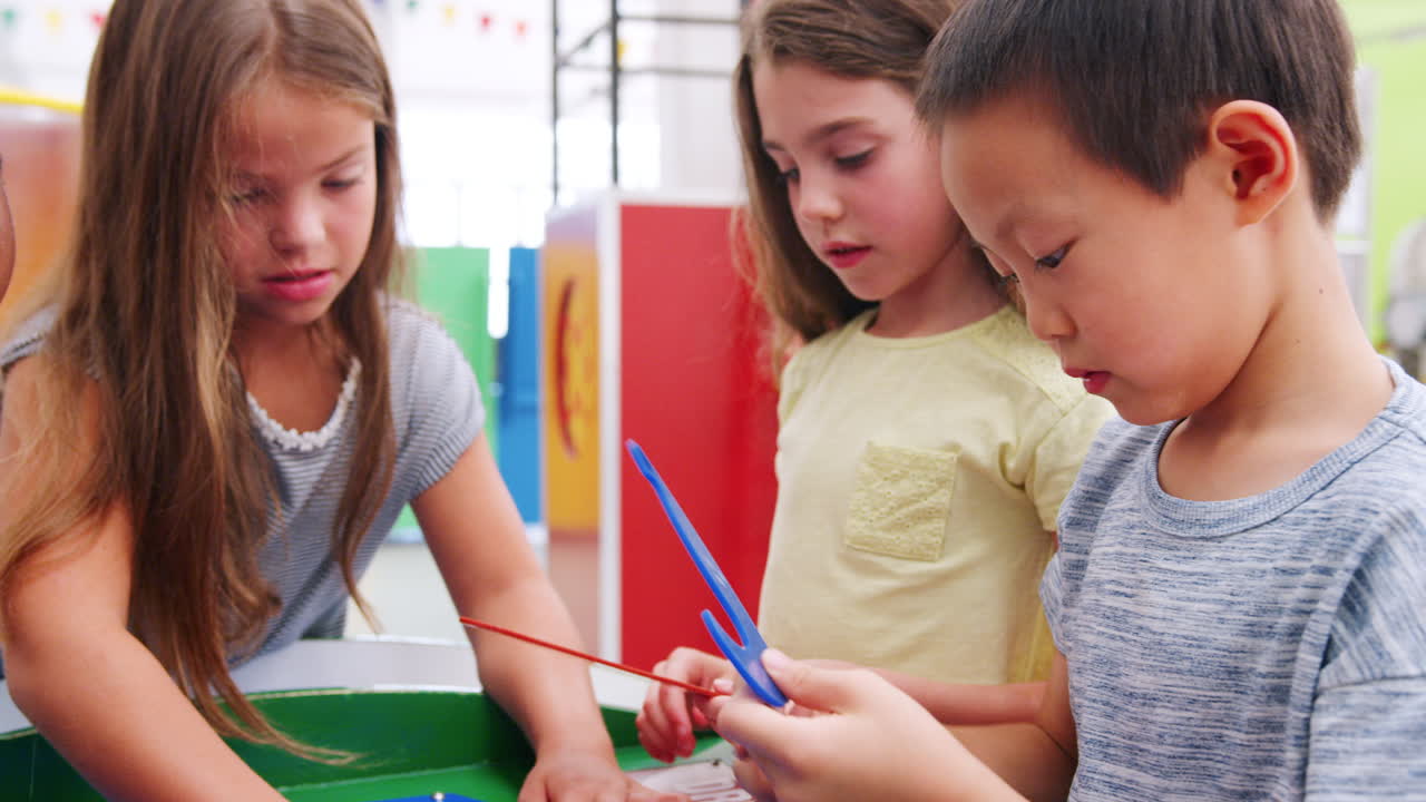 네 명의 아이들이 과학 센터에서 퍼즐을 풀고 있습니다.