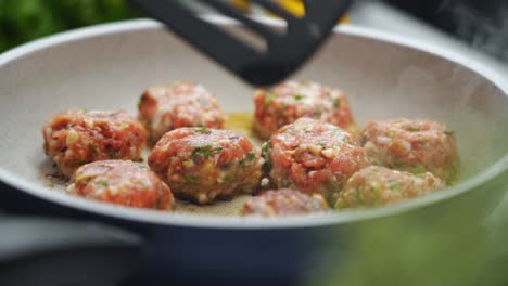 Unrecognizable-person-cooking-meatballs-on-frying-pan-with-oil