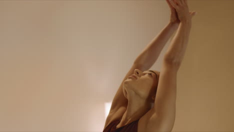 woman stretching hands in yoga studio. girl doing yoga in fitness studio