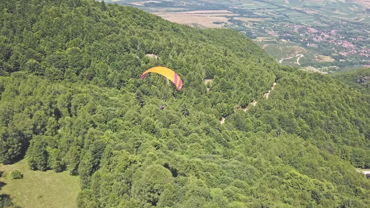 parapente sobre un paisaje de montaña verde y exuberante
