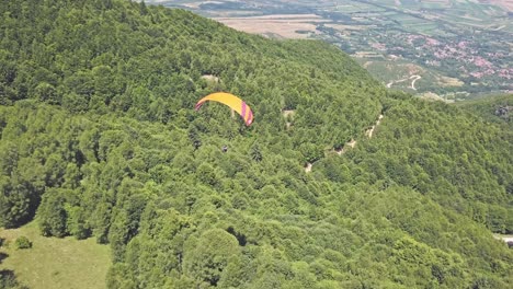 Parapente-Sobre-Un-Exuberante-Paisaje-De-Montaña-Verde