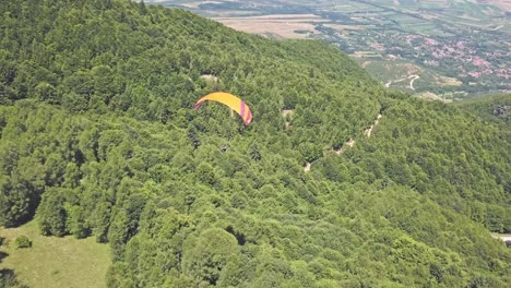 parapente sobre un paisaje de montaña verde y exuberante
