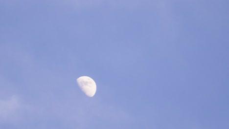 daytime moon with passing clouds slowly in tiemalapse shot