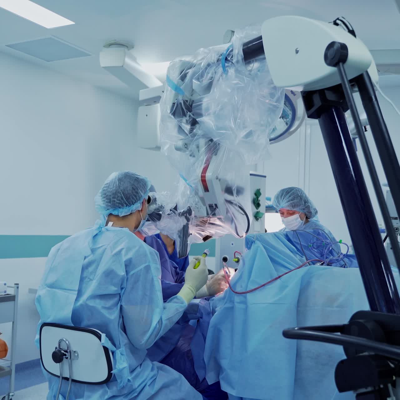 Neurosurgery in modern clinic. Group of doctors perform a surgery with the help of microscope. Contemporary equipment in the operating room.