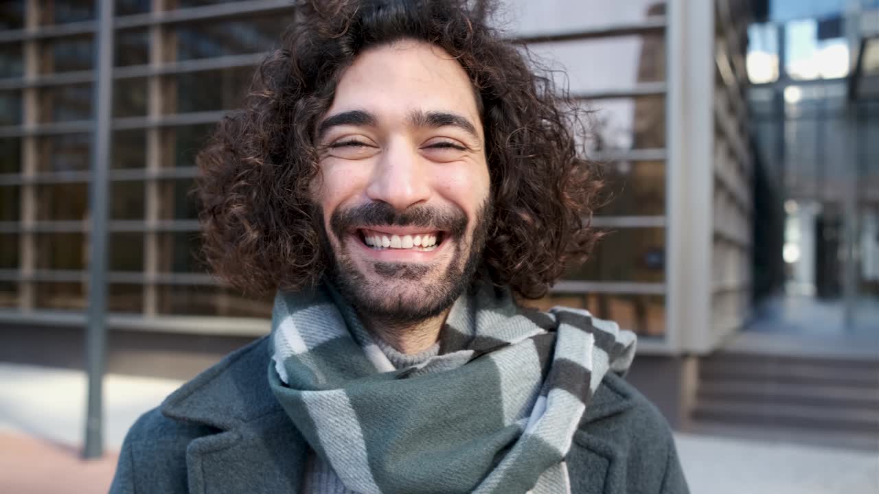 un joven hipster guapo mirando a la cámara en el distrito de negocios.