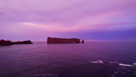 Drone-Avanzando-Hacia-La-Roca-Percé-Durante-Una-Puesta-De-Sol-Nublada