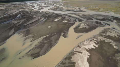 Murky-glacier-river-flows-through-lowland,-sunny-day-in-south-Iceland