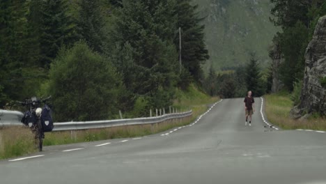 young caucasian male skateboarder trying and failing on a kickflip on a remote road in norway, scandinavia