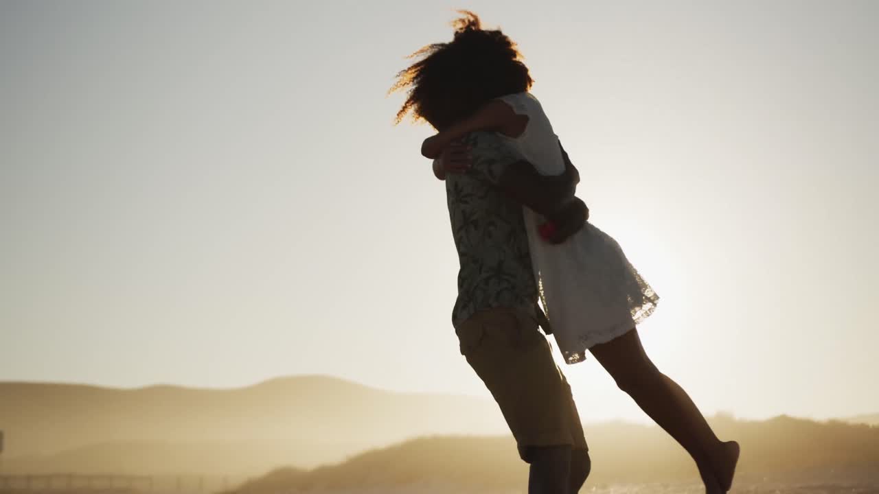 African American couple hugging at the beach