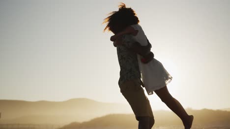 african american couple hugging at the beach