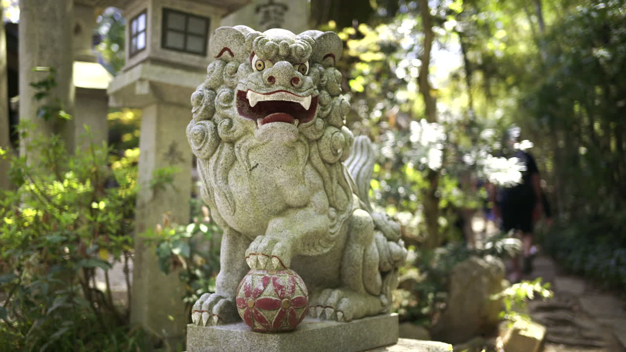 Fushimi Inari garden featuring a detailed lion statue, surrounded by vibrant greenery and decorative structures on a warm afternoon
