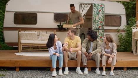 friends enjoying drinks by a trailer