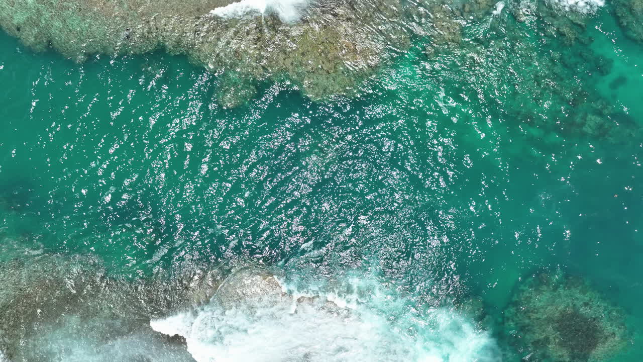 Drone top down static of open ocean water passage with no reef at center