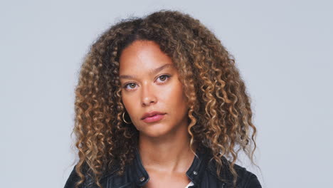 head and shoulders studio shot of woman looking at camera with serious expression in slow motion