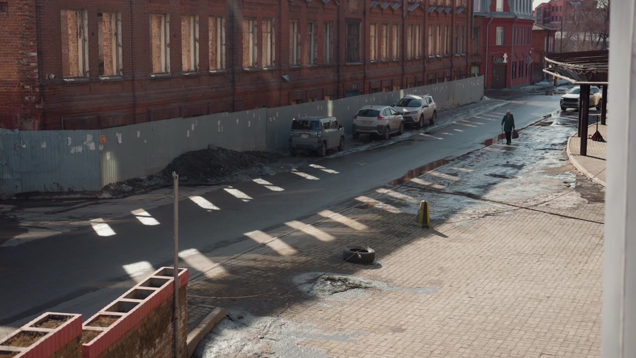 Pretty golden sunlit street, white courier crossing. Energetic city scene with brick buildings, parked cars, crosswalk stripes and dramatic elongated shadows. Frames capture brisk movement