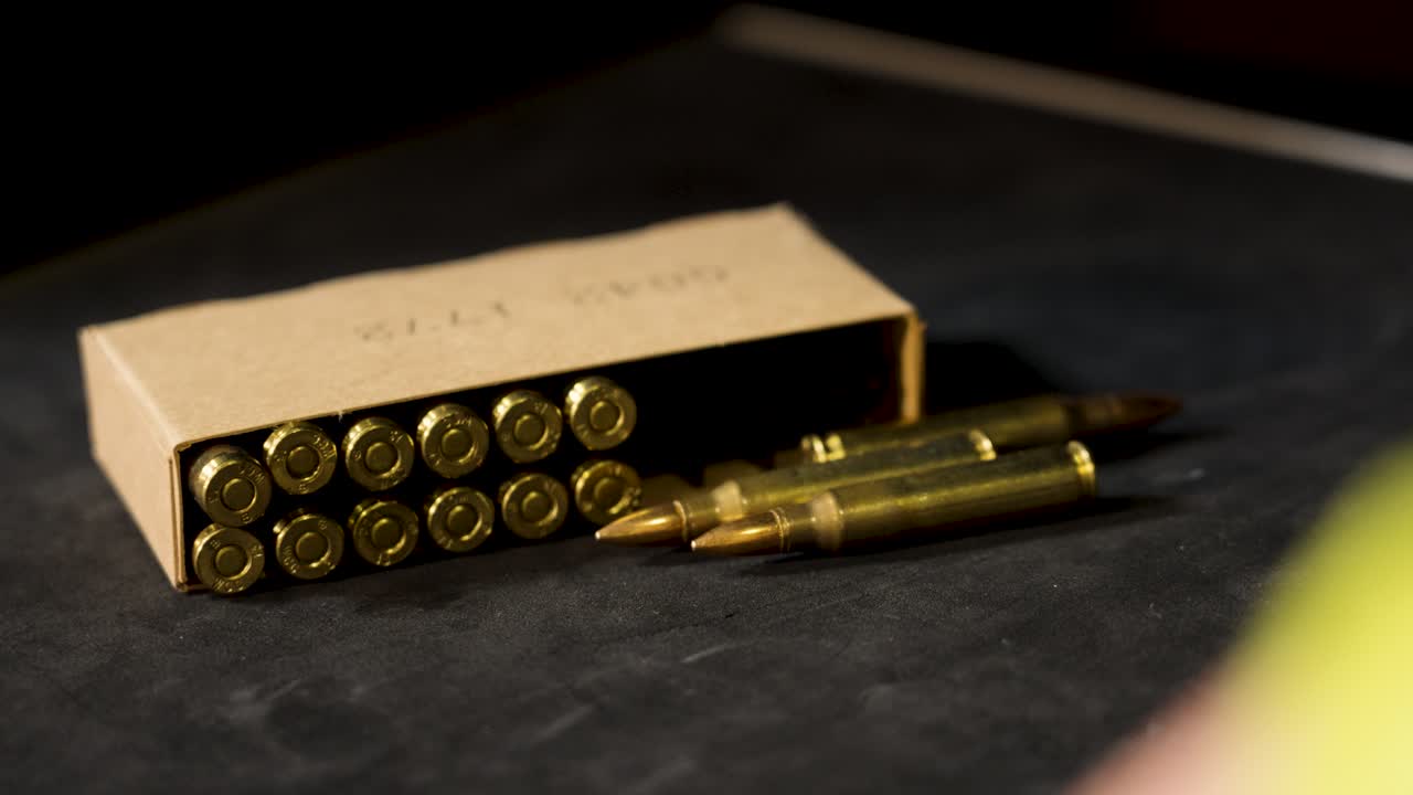 Close-up of a box of bullets and a hand