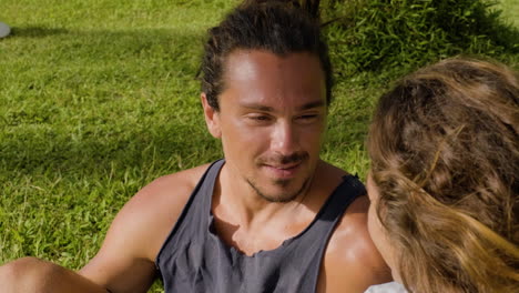 pareja joven sentada en la hierba