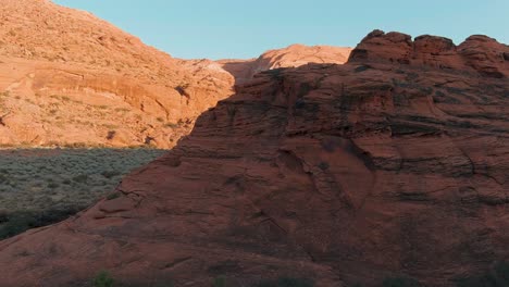 Aerial-orbiting-around-a-lava-flow-rock-to-reveal-a-much-larger-set-of-mountains-on-the-horizon