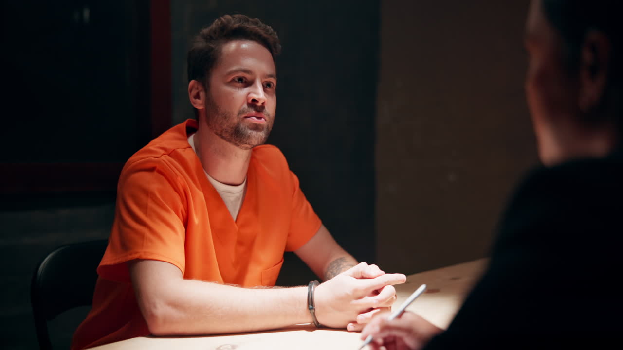 Man in orange jumpsuit being interviewed