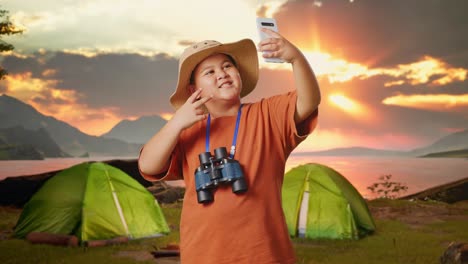 smiling boy taking a selfie while camping