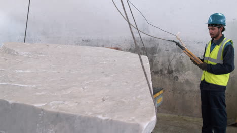 hombre levantando una pieza de mármol