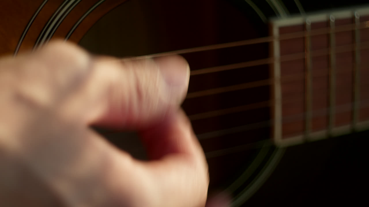 primer plano de manos tocando la guitarra acústica