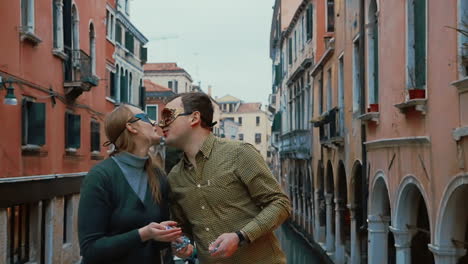 una pareja con máscaras venecianas lanzando confeti.