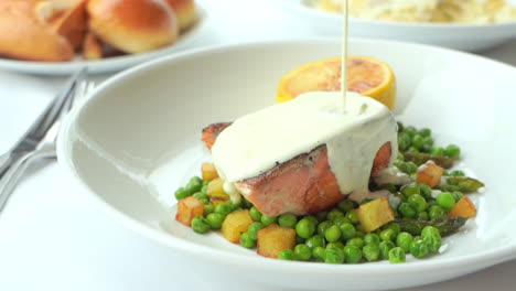 Salmon-Steak-Meal-With-Peas-and-White-Spread-Served-on-Plate
