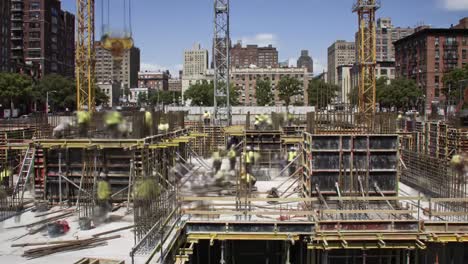 a busy construction site reveals workers collaborating to erect a large commercial building in a vibrant city. skylines loom, and the project progresses under clear skies.