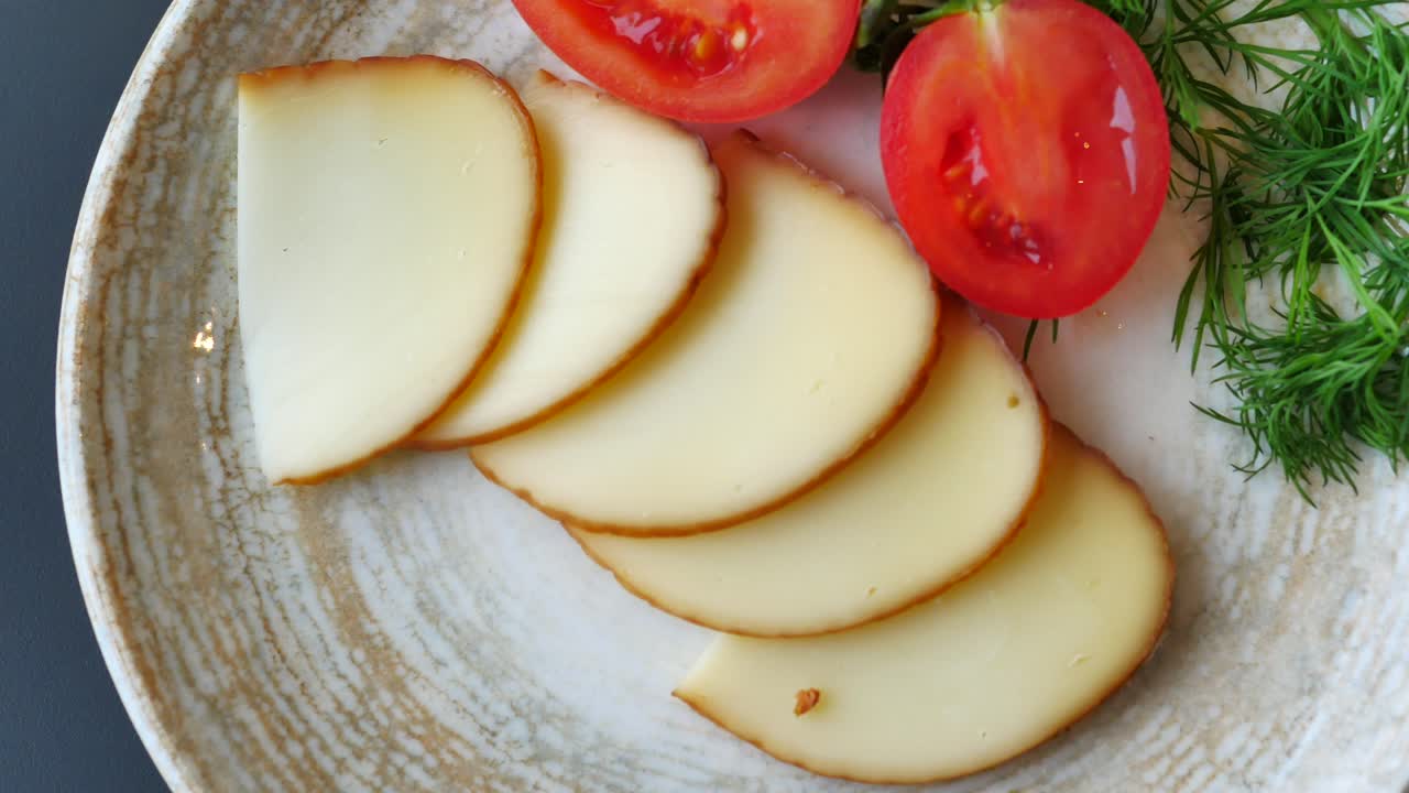 Skiveskåret ost med tomater og dild.
