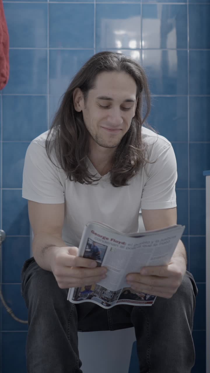 Uomo che legge il giornale sul water