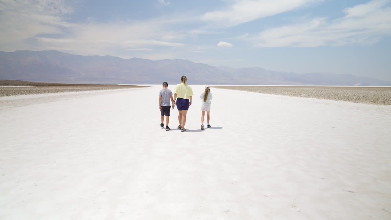 Family Walking Across a Vast Salt Flat in a Desert Landscape