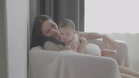 Mamá-Feliz-Levantando-A-Su-Lindo-Bebé-En-Casa