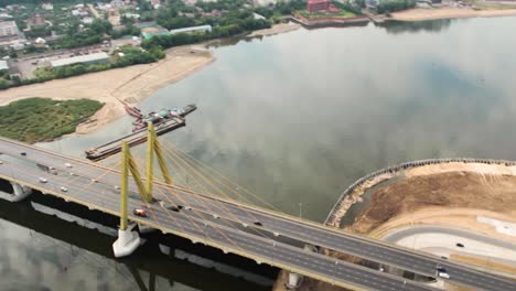 aerial view of a cable-stayed bridge over a river, construction site