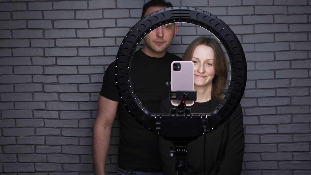 video de una pareja de bloggers con una lámpara led de anillo y un teléfono inteligente