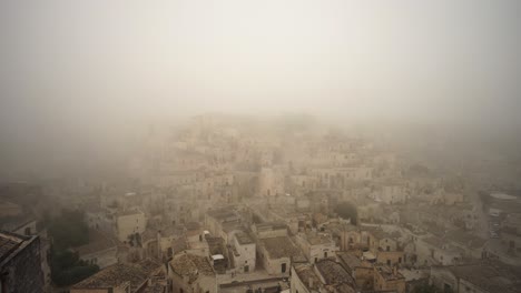 Panorámica-Lenta-A-La-Izquierda-Filmando-La-Ciudad-Vieja-De-Matera-Cubierta-De-Niebla-En-4k