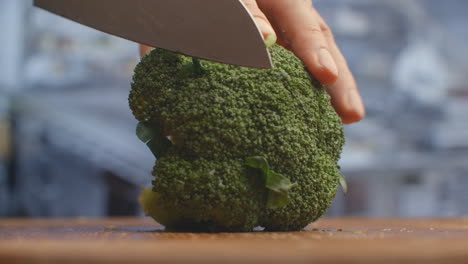 cut with a knife on a wooden board closeup broccoli in the kitchen. shred